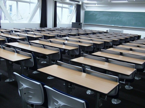 Lehrsaal mit Sitzplätzen und grüner Tafel