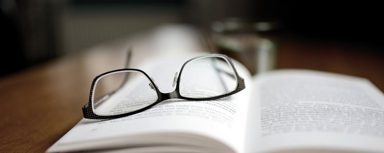 Brille auf offenem Buch