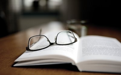 Brille auf offenem Buch
